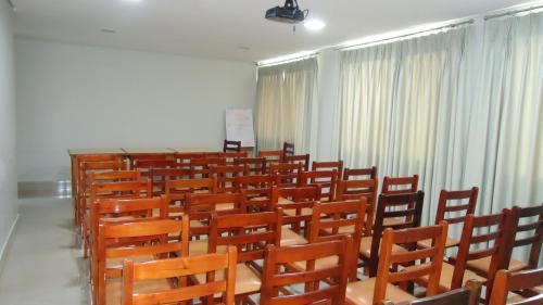 a room with rows of wooden chairs and curtains at Ilhabela Park Hotel in Brasilia