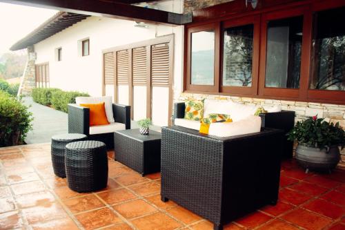 a patio with chairs and tables and windows at Pousada Recanto do Turvo in Capitólio