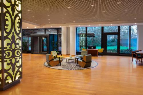 a lobby with chairs and tables in a building at Crowne Plaza Milan Linate by IHG in San Donato Milanese