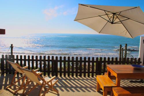 a patio with a table and chairs and an umbrella at Casa do Mar | Sea House | Apúlia in Apúlia