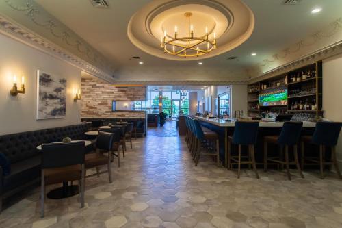 a dining room with a bar and a chandelier at Crowne Plaza Fredericton Lord Beaverbrook by IHG in Fredericton