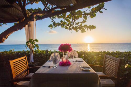 a table set up for a meal at a beach at Keyonna Beach Resort Antigua -All Inclusive in Saint Johnʼs