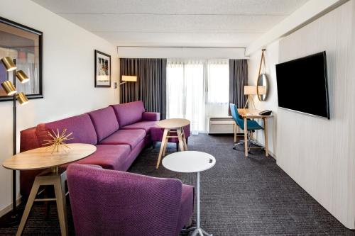 a living room with a purple couch and a table at Crowne Plaza Milwaukee Airport by IHG in Milwaukee