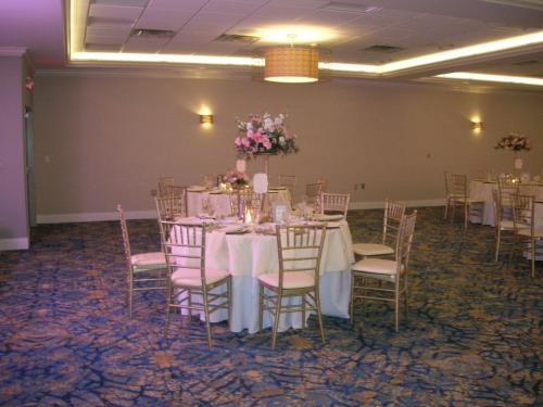 a banquet room with tables and chairs with flowers on them at Crowne Plaza Hotel and Suites Pittsburgh South by IHG in Pittsburgh
