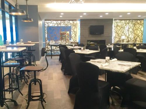 a dining room with tables and chairs and windows at Crowne Plaza Hotel and Suites Pittsburgh South by IHG in Pittsburgh