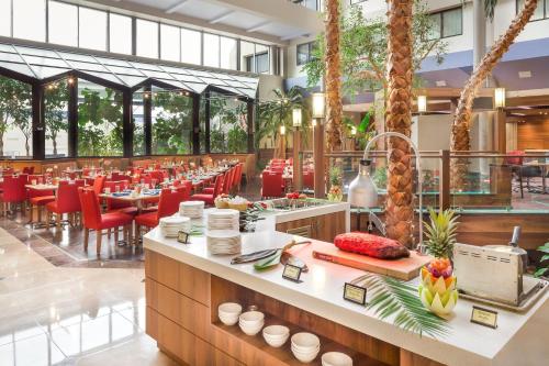 a restaurant with red chairs and tables in a building at Crowne Plaza Hotel Foster City-San Mateo by IHG in Foster City