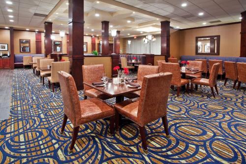 un restaurante con mesas y sillas en una alfombra en Ramada by Wyndham Cleveland Independence en Independence