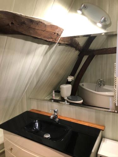 une salle de bain avec un lavabo et une baignoire dans l'établissement Aux doux logis, à Gouy-Saint-André