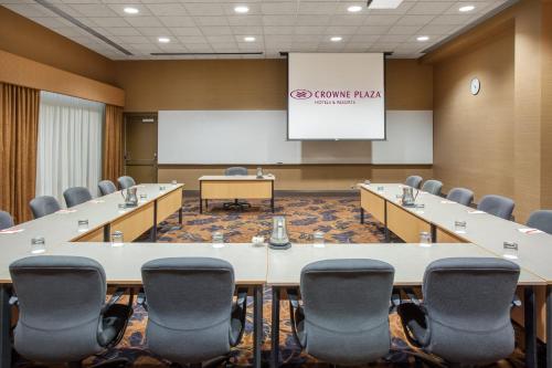 a conference room with tables and chairs and a screen at Crowne Plaza Minneapolis West by IHG in Plymouth