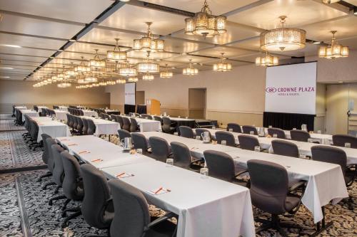 a conference room with white tables and chairs and chandeliers at Crowne Plaza Minneapolis West by IHG in Plymouth