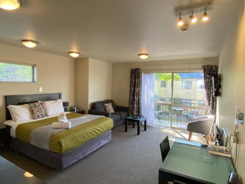 - une chambre avec un lit, un canapé et un bureau dans l'établissement Delago Motel/Apartments, à Christchurch