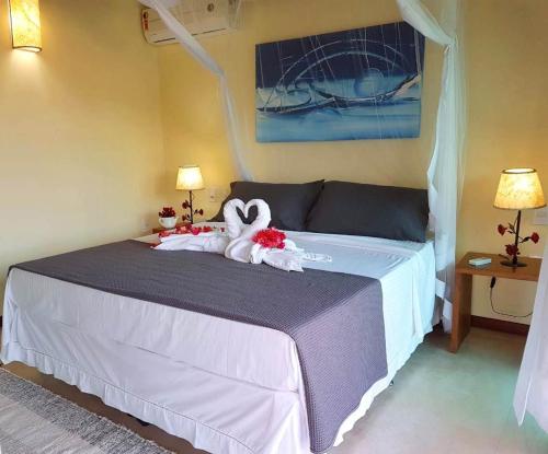 a bedroom with a bed with a stuffed animal on it at BELLA VISTA Village in Arraial d'Ajuda