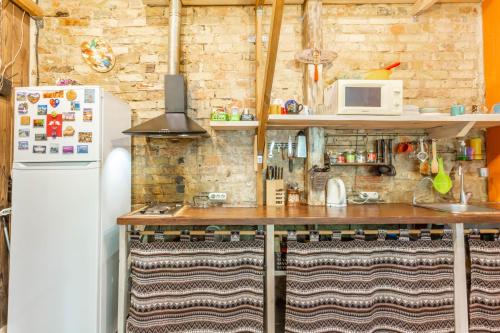 a kitchen with a refrigerator, sink, and cabinets at FACTORY Hostel in Kyiv