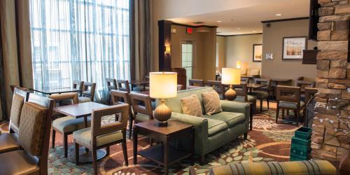 a hotel lobby with a couch and tables and chairs at Staybridge Suites Fargo by IHG in Fargo