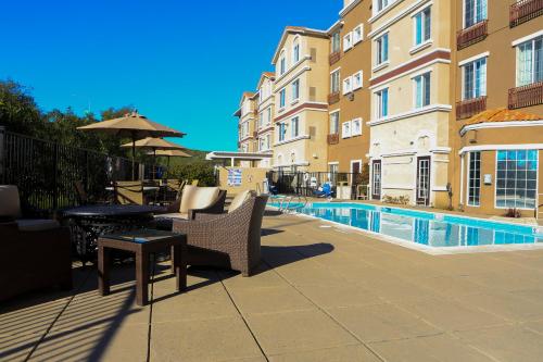 a patio with a table and chairs next to a pool at Staybridge Suites Silicon Valley - Milpitas by IHG in Milpitas