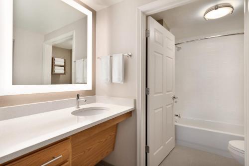 a white bathroom with a sink and a mirror at Staybridge Suites San Antonio Downtown Convention Center by IHG in San Antonio
