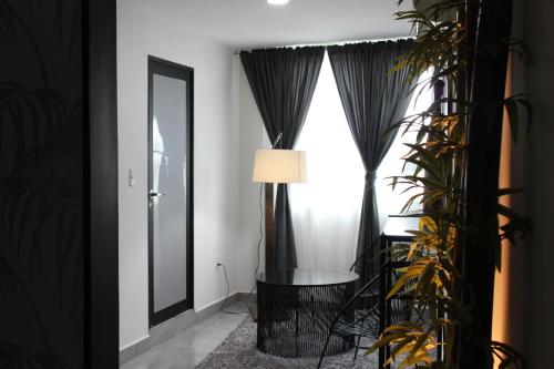a room with black curtains and a table and a mirror at Hotel Florencia Poza Rica in Poza Rica de Hidalgo