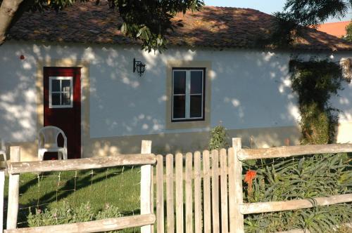 a white house with a fence in front of it at Casa da Tia Guida in Golegã