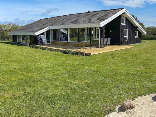 a house with a porch and a large yard at 10 person holiday home in Hjørring-By Traum in Lønstrup