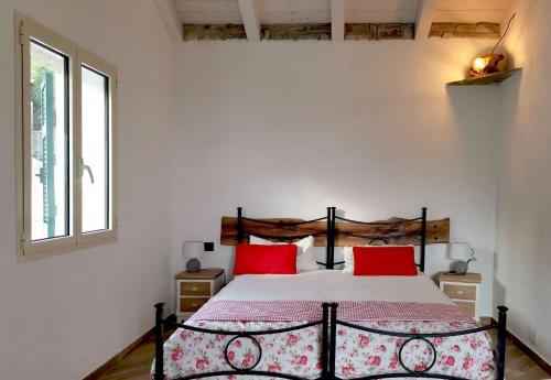 ein Schlafzimmer mit einem Bett mit roten Kissen in der Unterkunft Holiday home in Pompeiana 40835 in Pompeiana