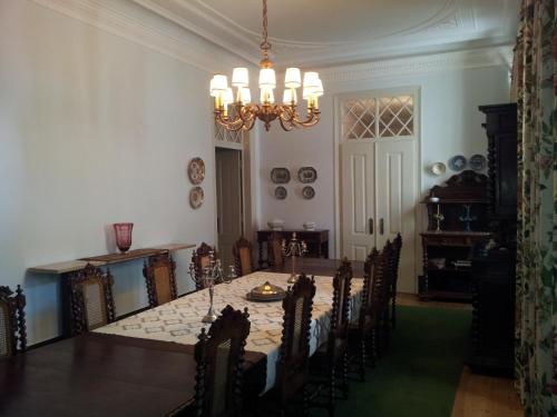 uma sala de jantar com uma mesa e cadeiras e um lustre em Casa da Tia Guida na Golegã