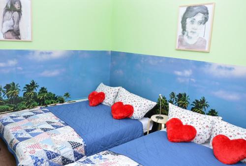 a bedroom with two beds with red hearts cushions at SUITE Top View & City Alex 4 rooms 2 bathrooms 1 kitchen in Berlin