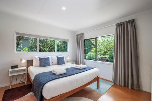 a bedroom with a large bed and two windows at Lakeview Lookout in Taupo