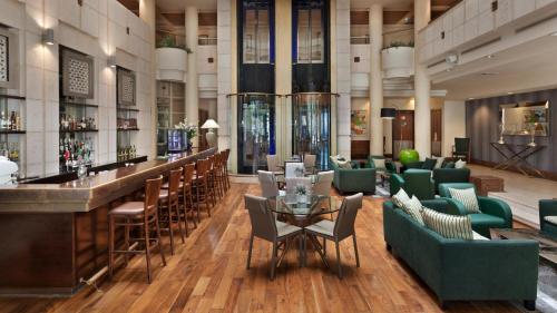 a hotel lobby with a bar and chairs at Crowne Plaza Haifa by IHG in Haifa