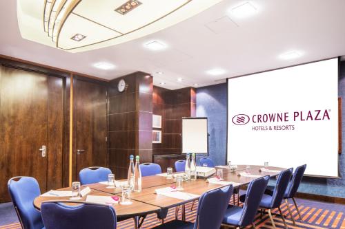 a conference room with a long table and blue chairs at Crowne Plaza London - Gatwick Airport by IHG in Crawley