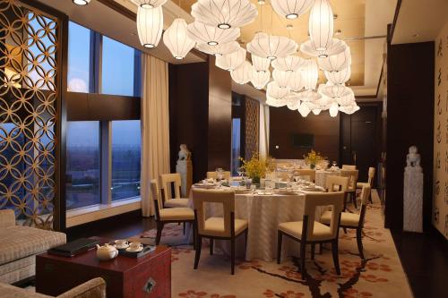 a dining room with a table and chairs and chandeliers at Crowne Plaza Tianjin Binhai by IHG in Tianjin