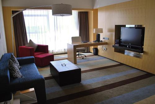 a living room with a couch and a tv at Crowne Plaza Tianjin Binhai by IHG in Tianjin