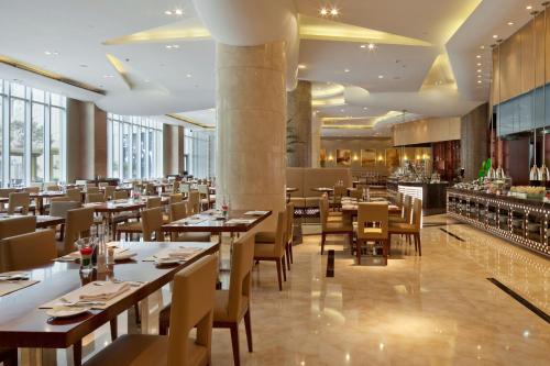 a restaurant with tables and chairs and a bar at Crowne Plaza Tianjin Binhai by IHG in Tianjin
