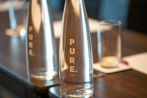 two glasses are sitting on a wooden table at Crowne Plaza London - Gatwick Airport by IHG in Crawley