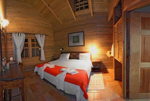 Cette chambre en bois comprend un grand lit. dans l'établissement Finca Hamburgo La Ruta del Cafe, à Tapachula