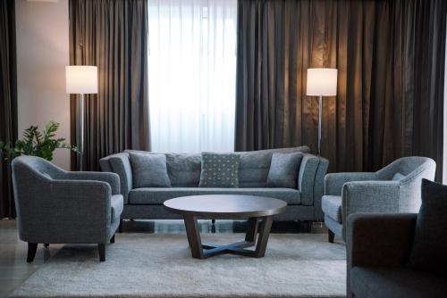 a living room with a couch and chairs and a table at Crowne Plaza Managua by IHG in Managua