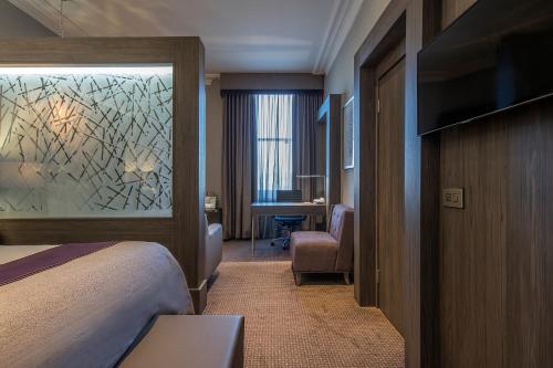 a hotel room with a bed and a desk at Crowne Plaza - Sheffield by IHG in Sheffield