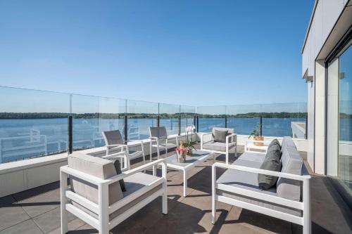 a balcony with white chairs and tables on a yacht at Golden Lakes Hotel in Boussu-lez-Walcourt