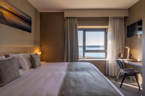 a hotel room with a large bed and a window at Golden Lakes Hotel in Boussu-lez-Walcourt