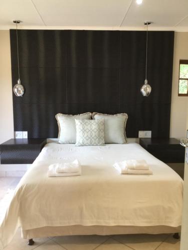 a bedroom with a large bed with two towels on it at Shais Beach Getaway in Port Edward