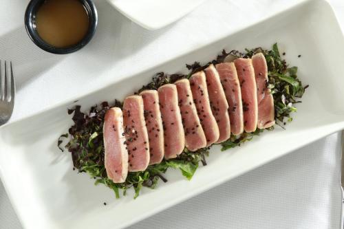 a white plate with four ham and greens on it at Crowne Plaza Leon by IHG in León