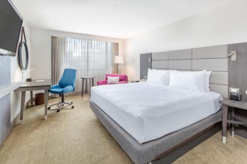 a bedroom with a bed and a desk and a chair at Crowne Plaza San Jose La Sabana by IHG in San José