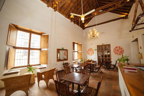 a dining room with tables and chairs and windows at Bioma Boutique Hotel in Mompos