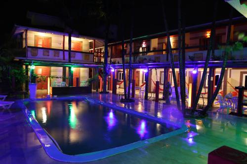 Hotel Ferrugem Eco Village في غاروبابا: مسبح فارغ امام مبنى في الليل