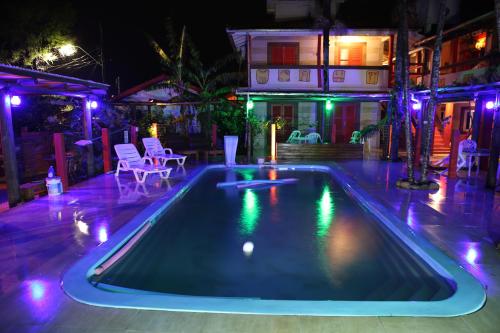 una piscina por la noche con luces en Hotel Ferrugem Eco Village en Garopaba