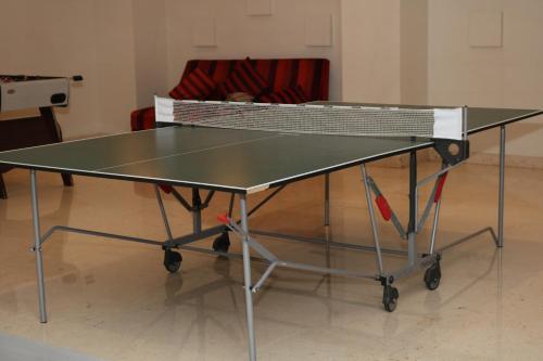 a ping pong table in a room with a couch at Crowne Plaza Sohar by IHG in Sohar