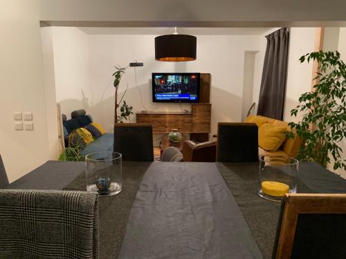 sala de estar con mesa de comedor y TV en Agréable Logement à Vierzon, en Vierzon