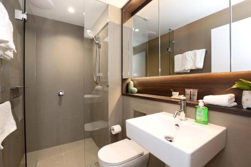 a bathroom with a sink and a toilet and a shower at Orange Stay at Melbourne Quarter in Melbourne