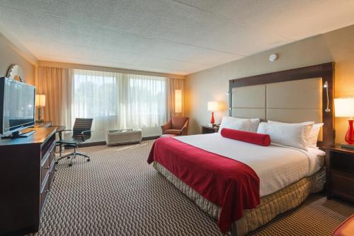 a hotel room with a bed and a flat screen tv at Crowne Plaza Boston - Woburn by IHG in Woburn
