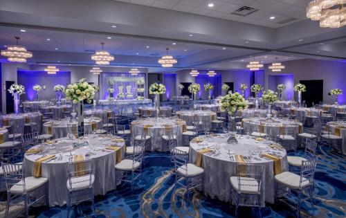 a ballroom filled with tables and chairs with flowers at Crowne Plaza Boston - Woburn by IHG in Woburn