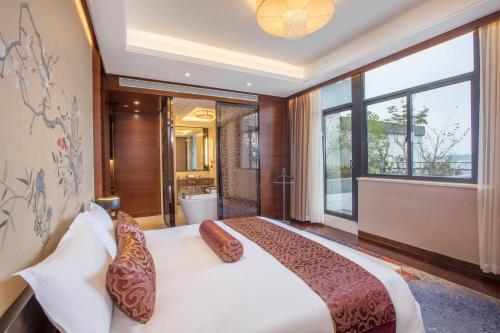 a bedroom with a large bed and a large window at Crowne Plaza Huangshan Yucheng by IHG in Huangshan